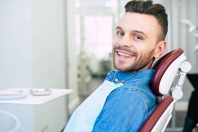 man smiling in dental chair after periodontal exam in mesquite