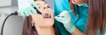 woman getting teeth cleaned in Mesquite dental office