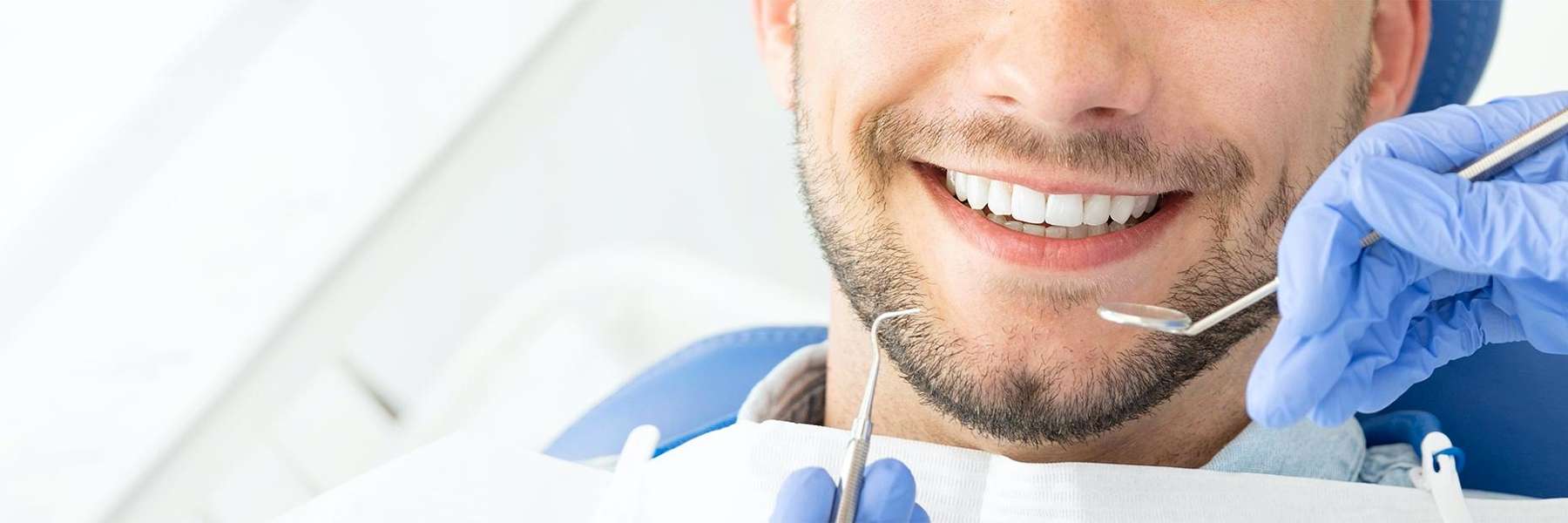 man smiling while getting dental exam in mesquite
