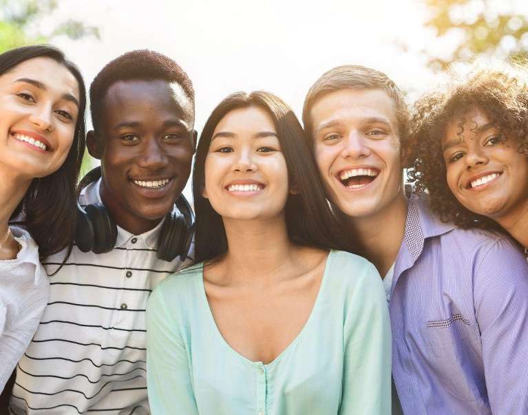 group of five adults smiling | veneers mesquite tx