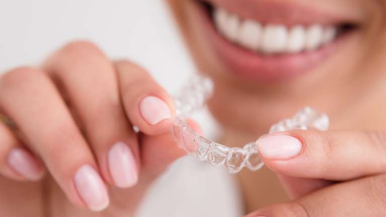 patient holding clear aligners | invisalign clear aligners mesquite tx