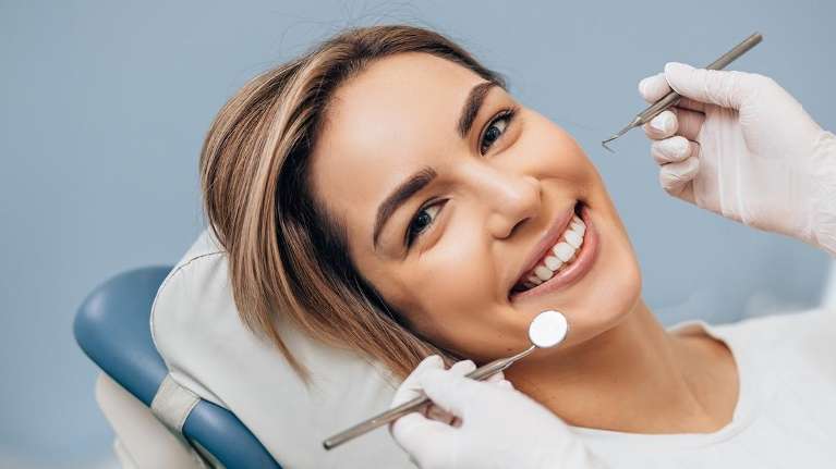woman smiling in dentist exam chair | gum disease treatment mesquite tx