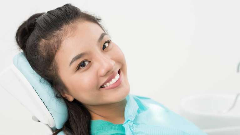 woman sitting in a dental chair waiting for teeth cleaning